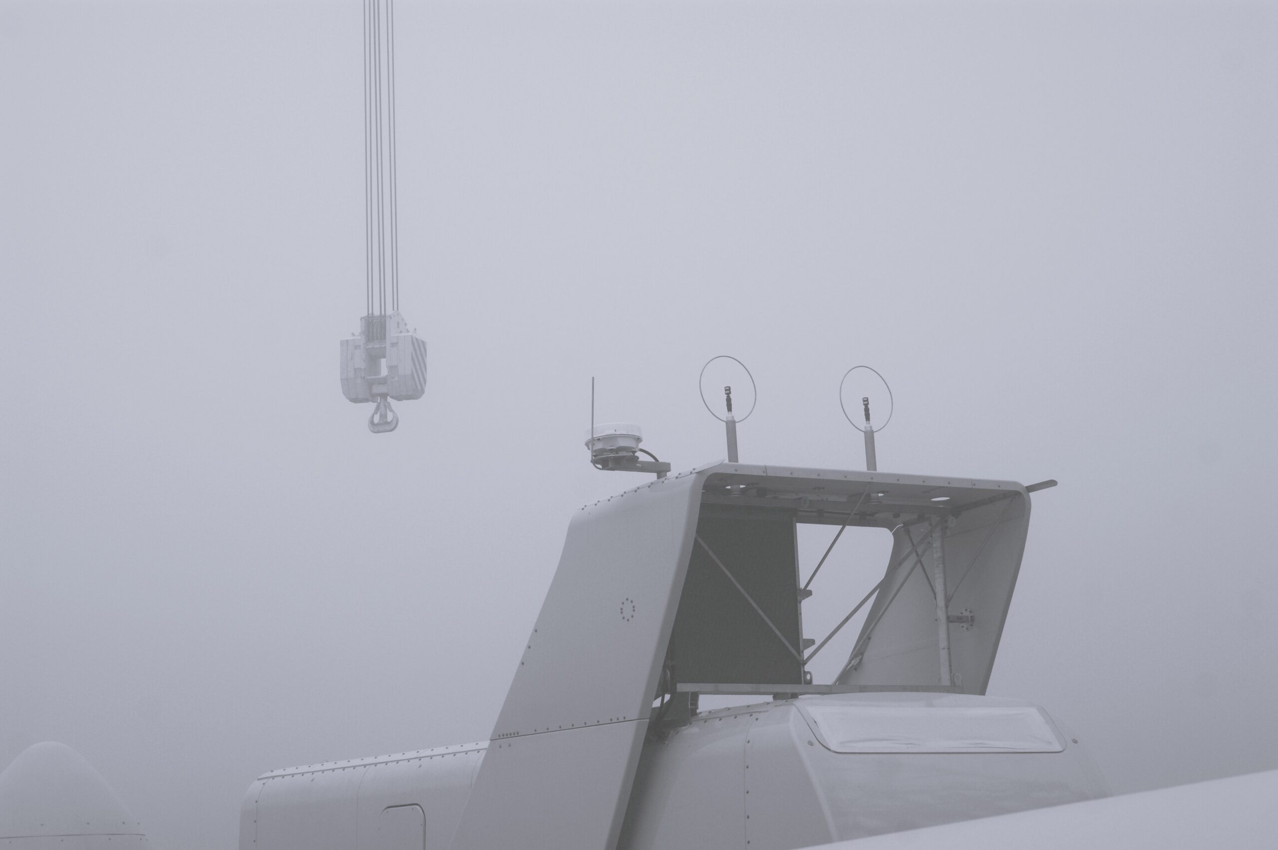 Gondola elektrowni Vestas V100 podczas montażu. Mglisty krajobraz, widoczny fragment dźwigu.